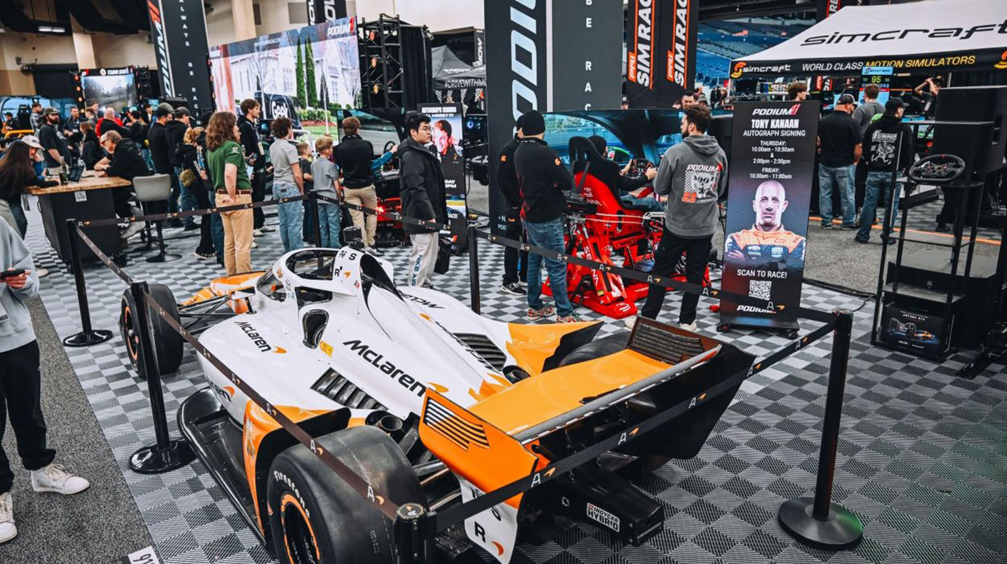 Cars and attendees on the PRI Show floor.