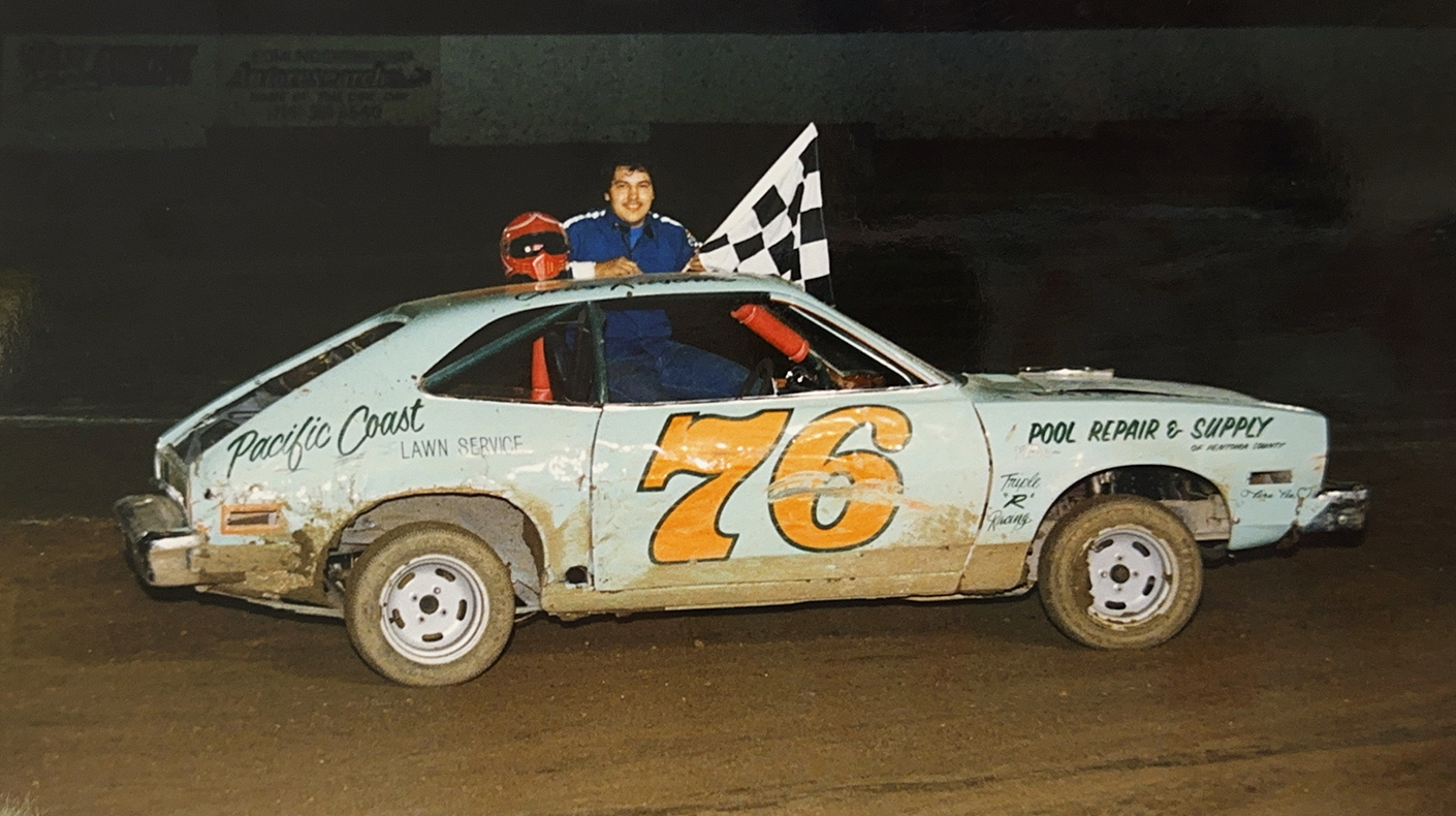 Photo of young Chris Raschke leaning on top of his race car.