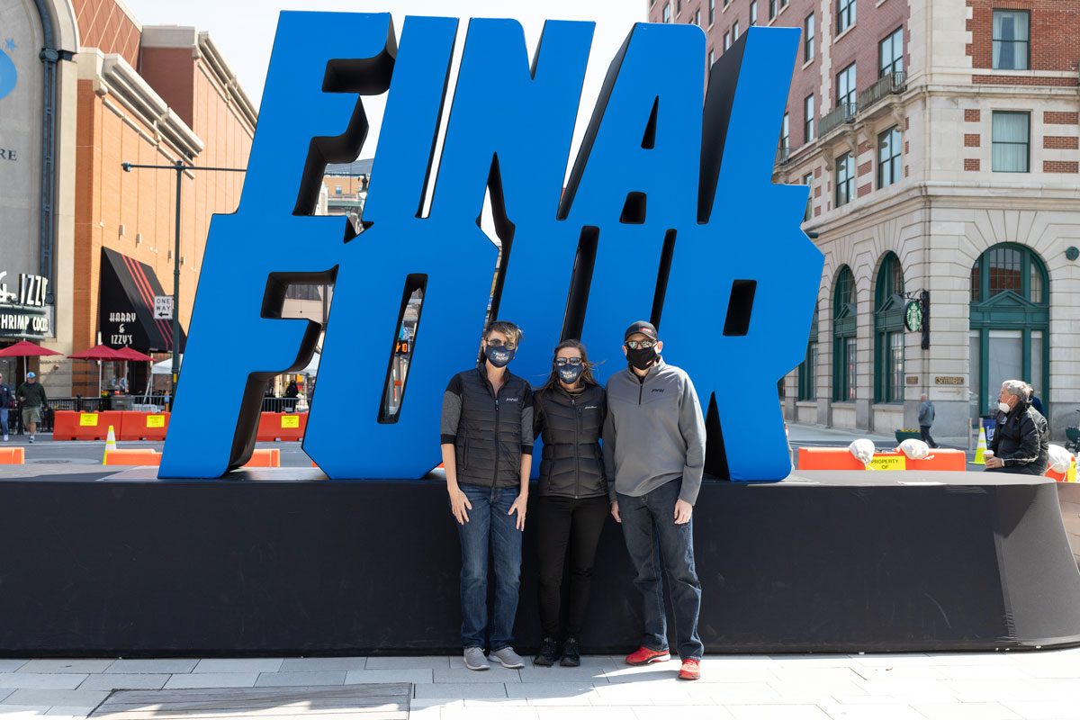 PRI team members in front of Final Four sign