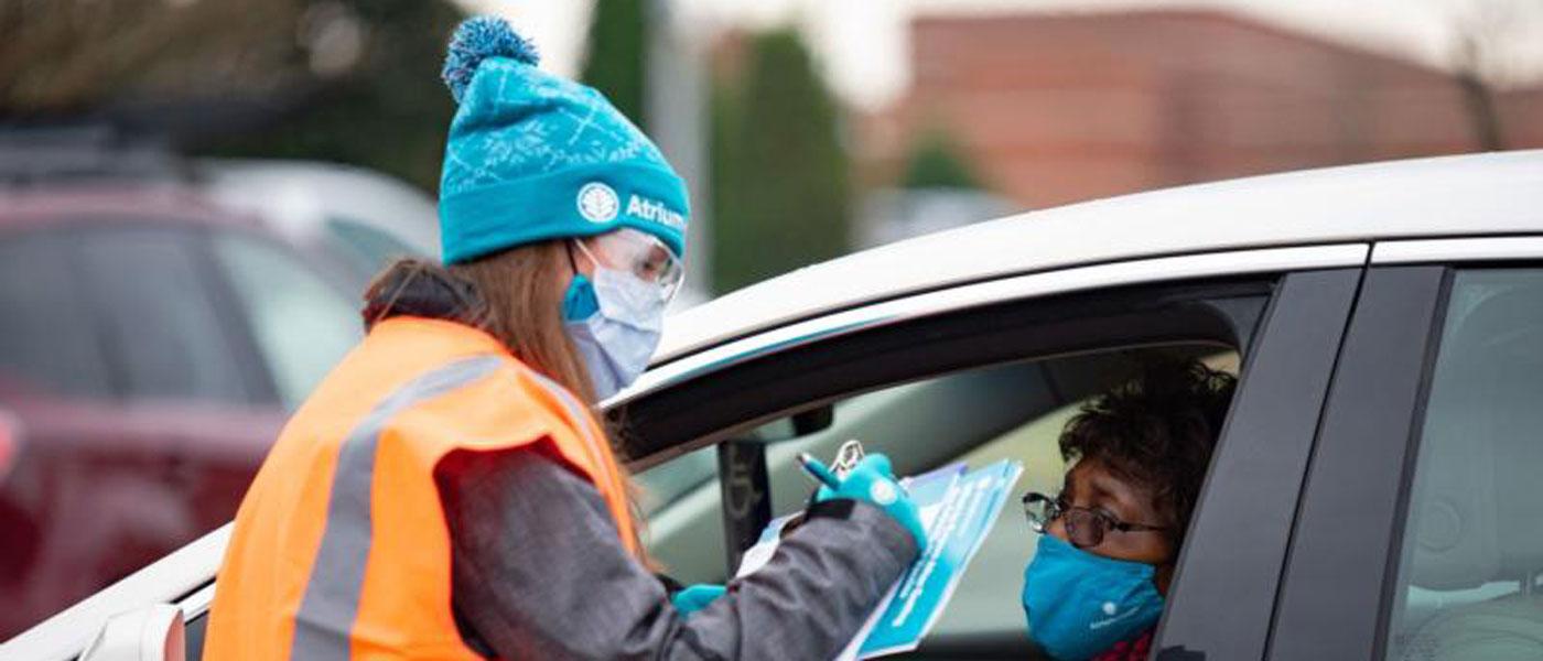 Photo courtesy of Atrium Health. Healthcare worker and person in car at drive through vaccination site