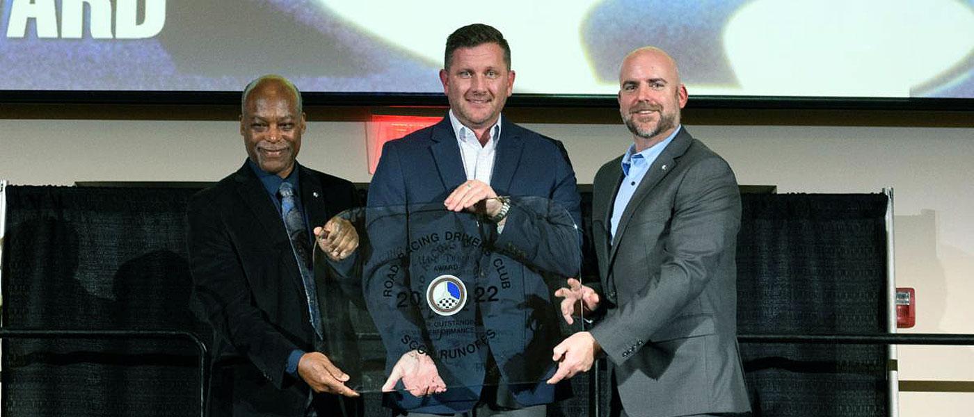 Jason Ott, center, accepts the RRDC Mark Donohue Award from Calvin Stewart, left, and Eric Prill. Photo by Wes Duenkel.