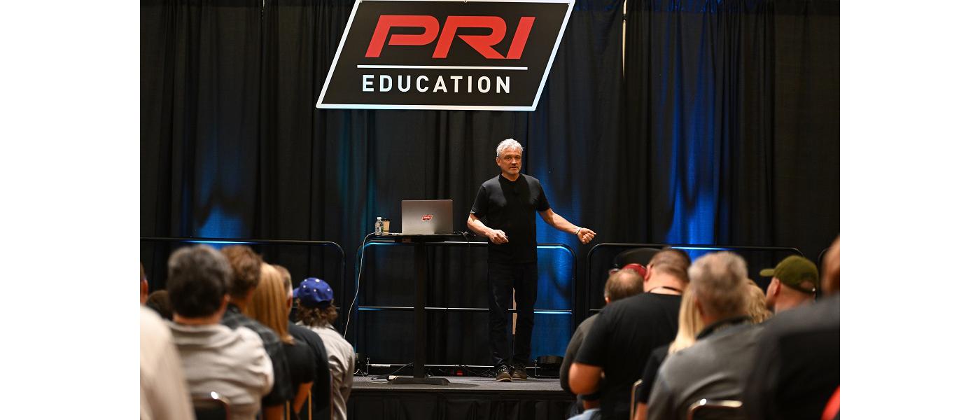 A presenter giving a lecture on the PRI education stage