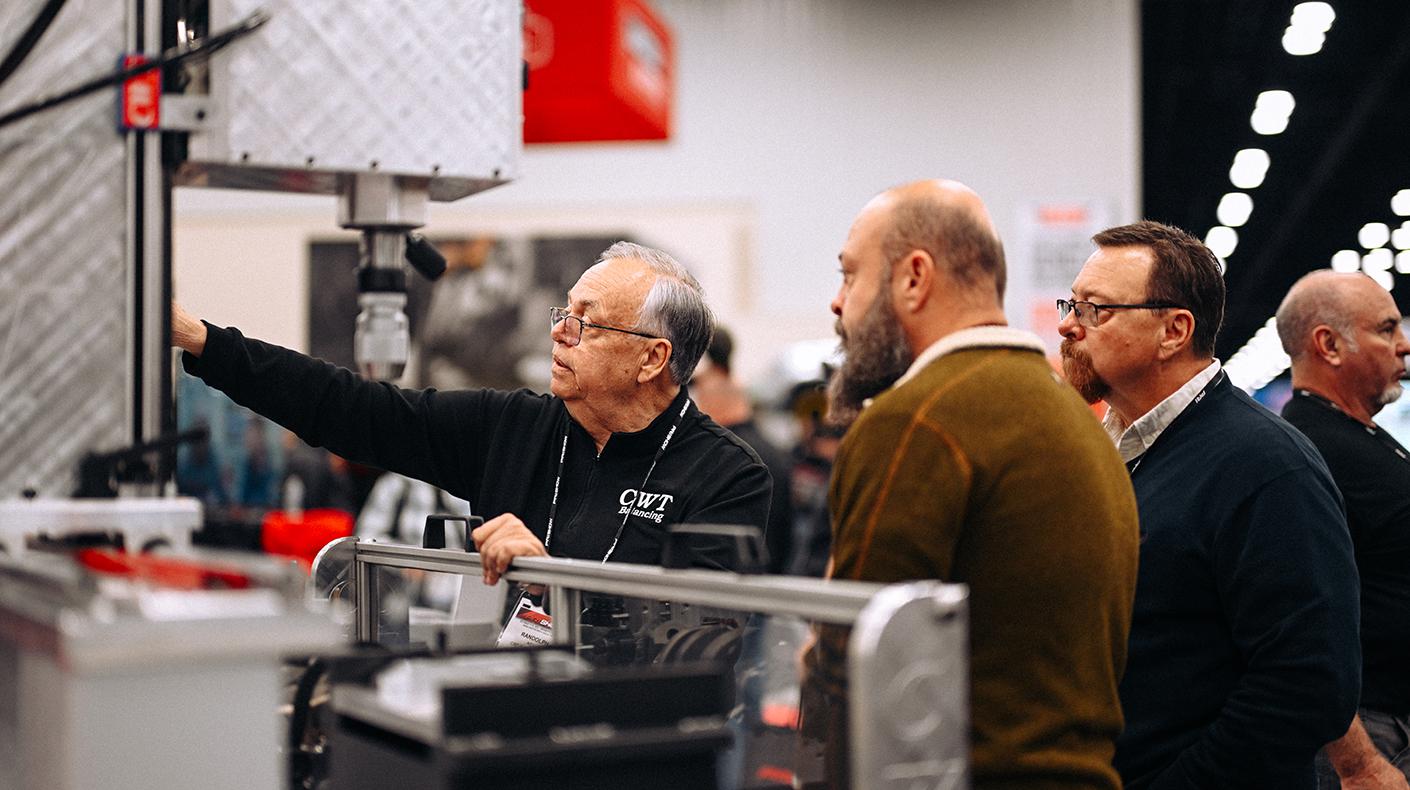 An exhibitor speaking with attendees at the PRI Show.
