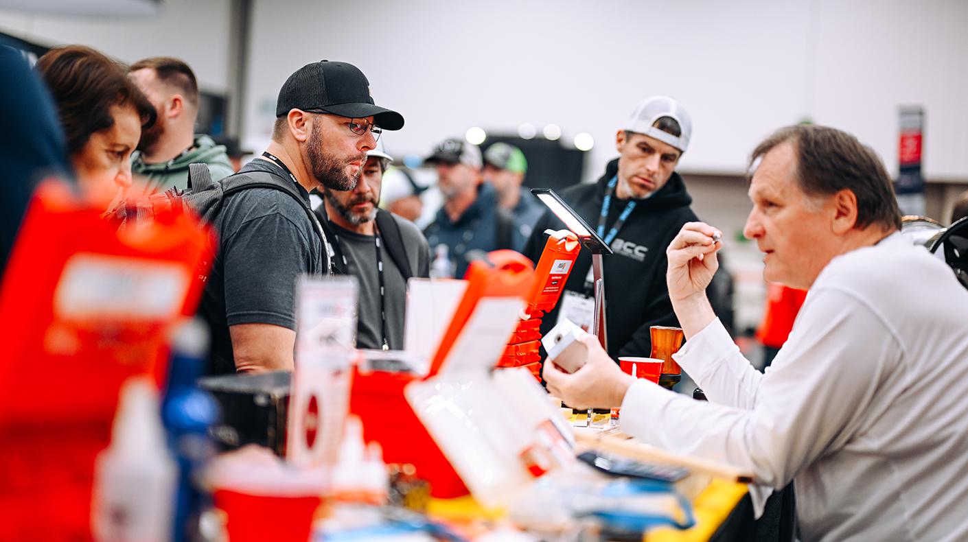 PRI Show attendees talking to exhibitors.