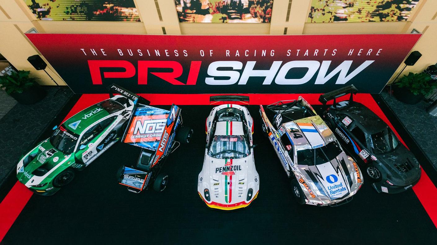 A variety of race cars on the PRI Show floor