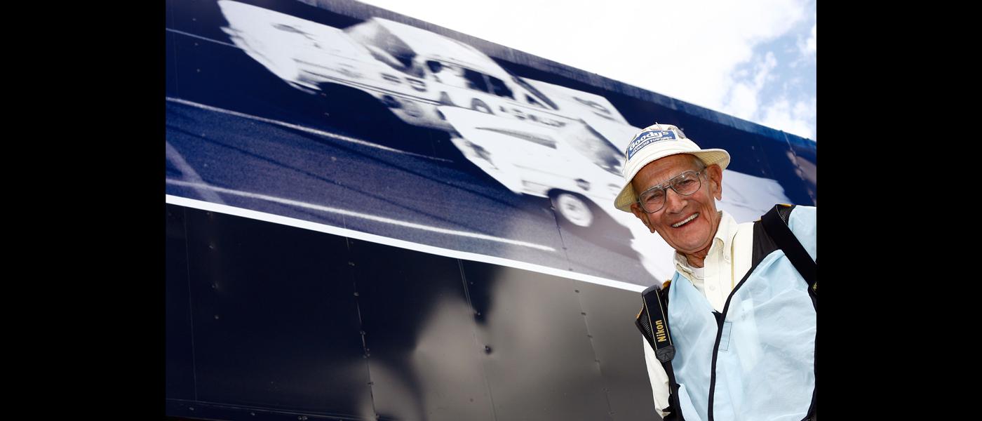 Before the 50th running of the Daytona 500 in 2008, T. Taylor Warren poses next to his famous photo of the three-wide finish at the first Daytona 500 in 1959. Photo courtesy of NASCAR.