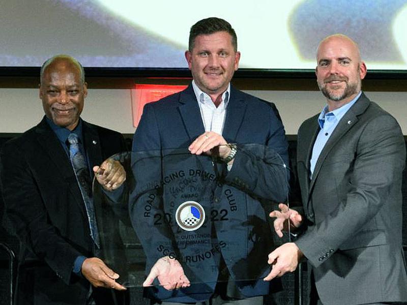 Jason Ott, center, accepts the RRDC Mark Donohue Award from Calvin Stewart, left, and Eric Prill. Photo by Wes Duenkel.
