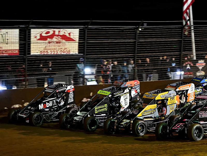 Midget cars line up for the start of a race