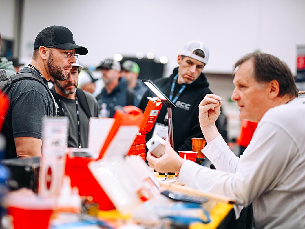PRI Show attendees talking to exhibitors.