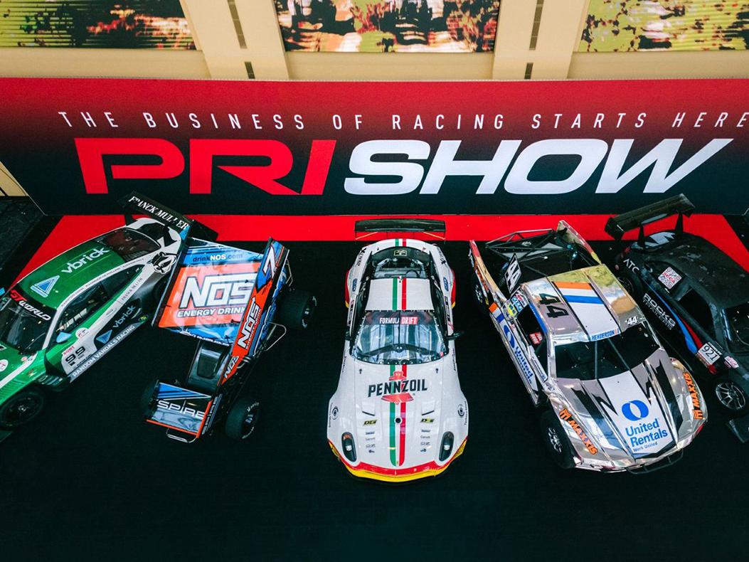 A variety of race cars on the PRI Show floor
